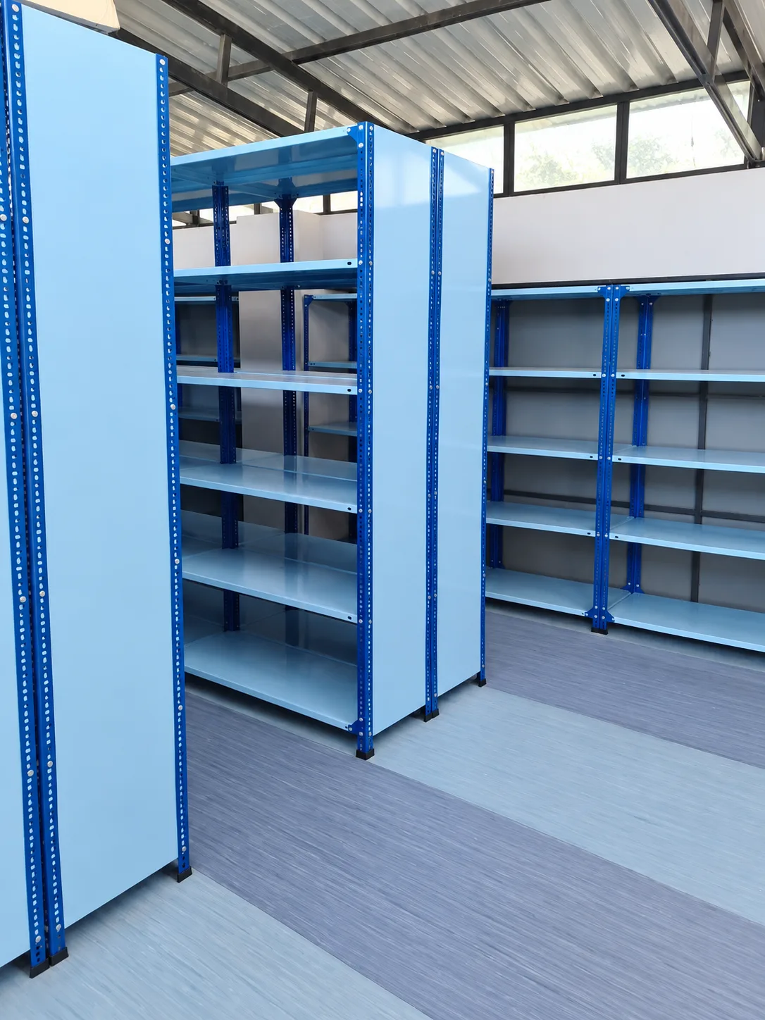 Blue steel shelving installed along a storage aisle.