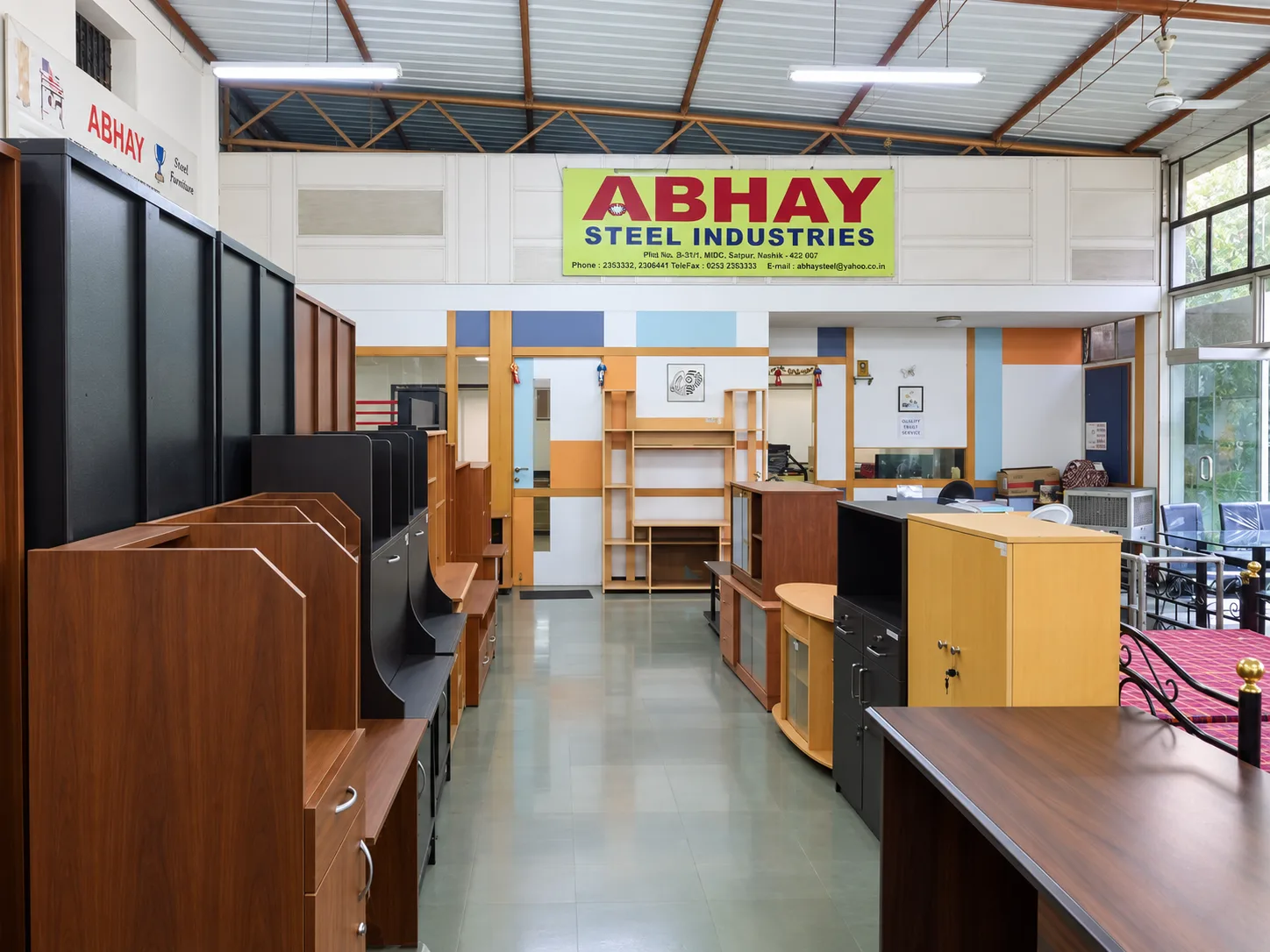 The Abhay Steel Industries sign above the showroom aisle at MIDC Satpur