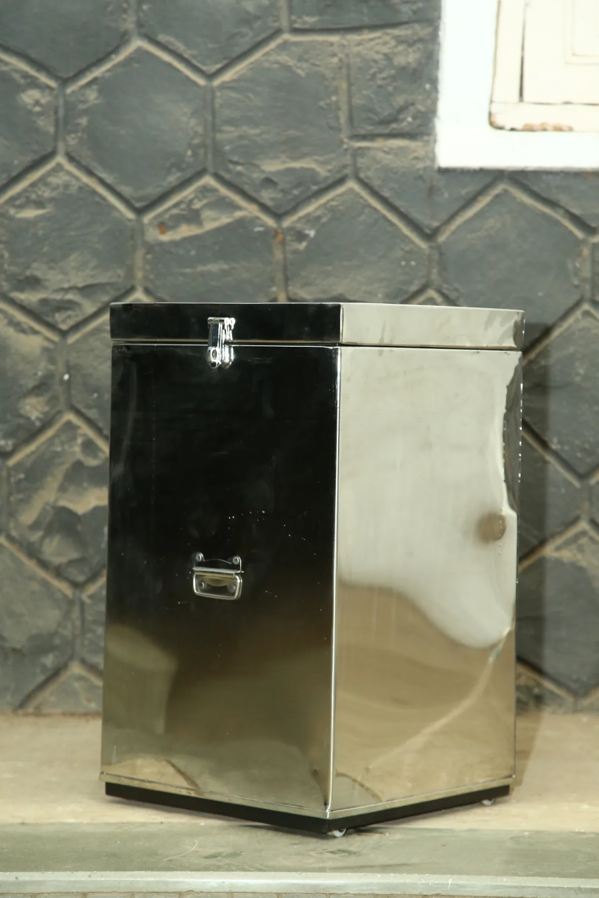 Stainless steel container with a hinged lid.