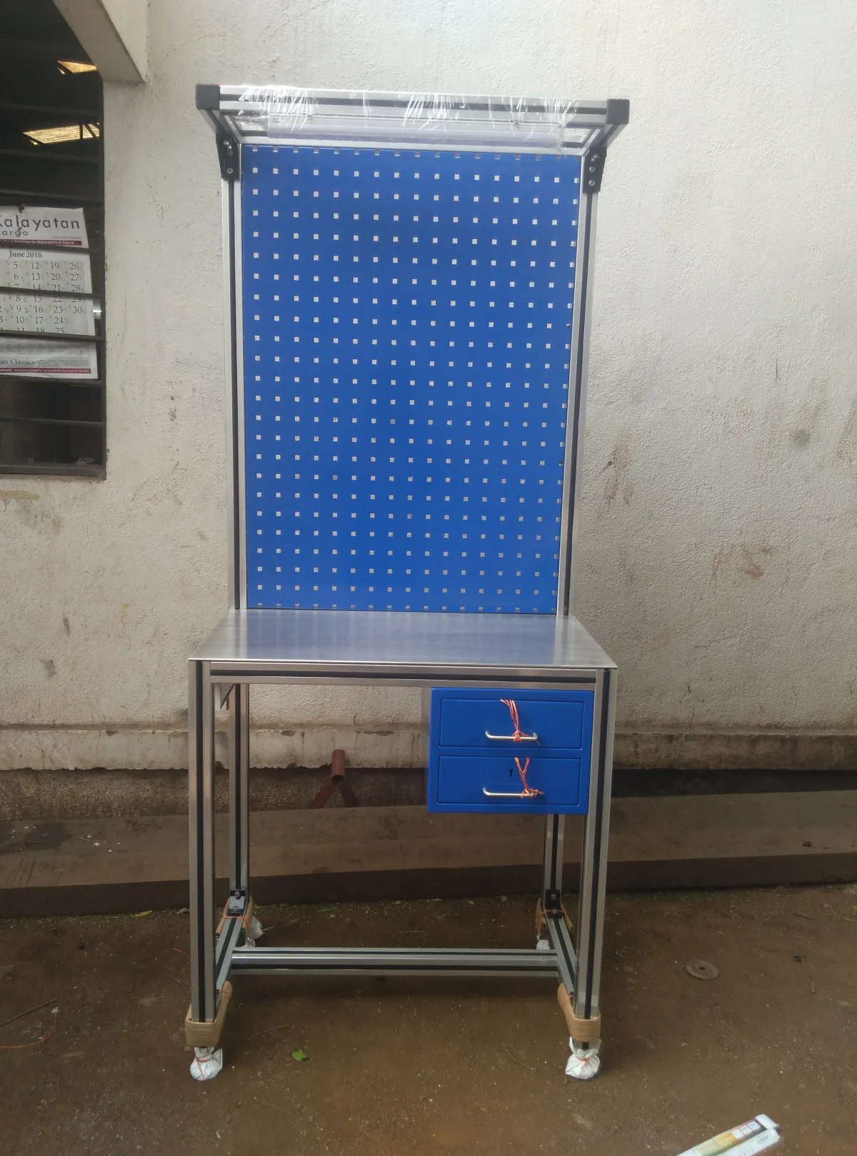 Workstation table with a pegboard tool panel.