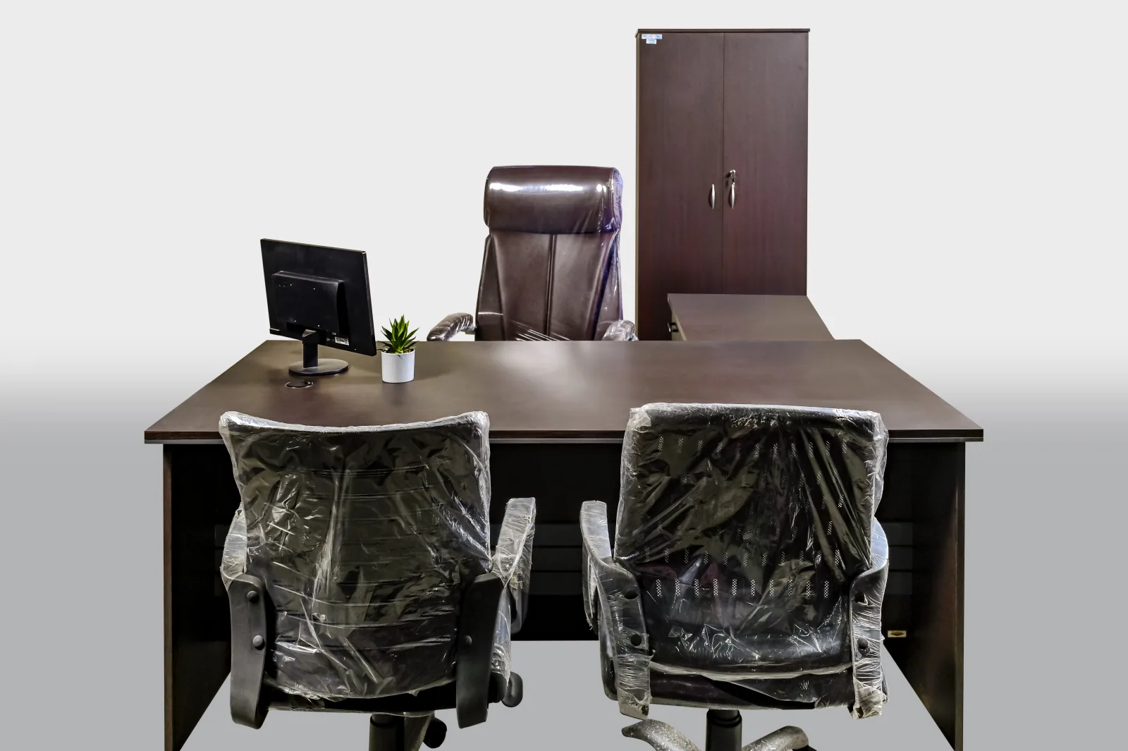A manager's cabin: desk, two visitor chairs, cupboard.
